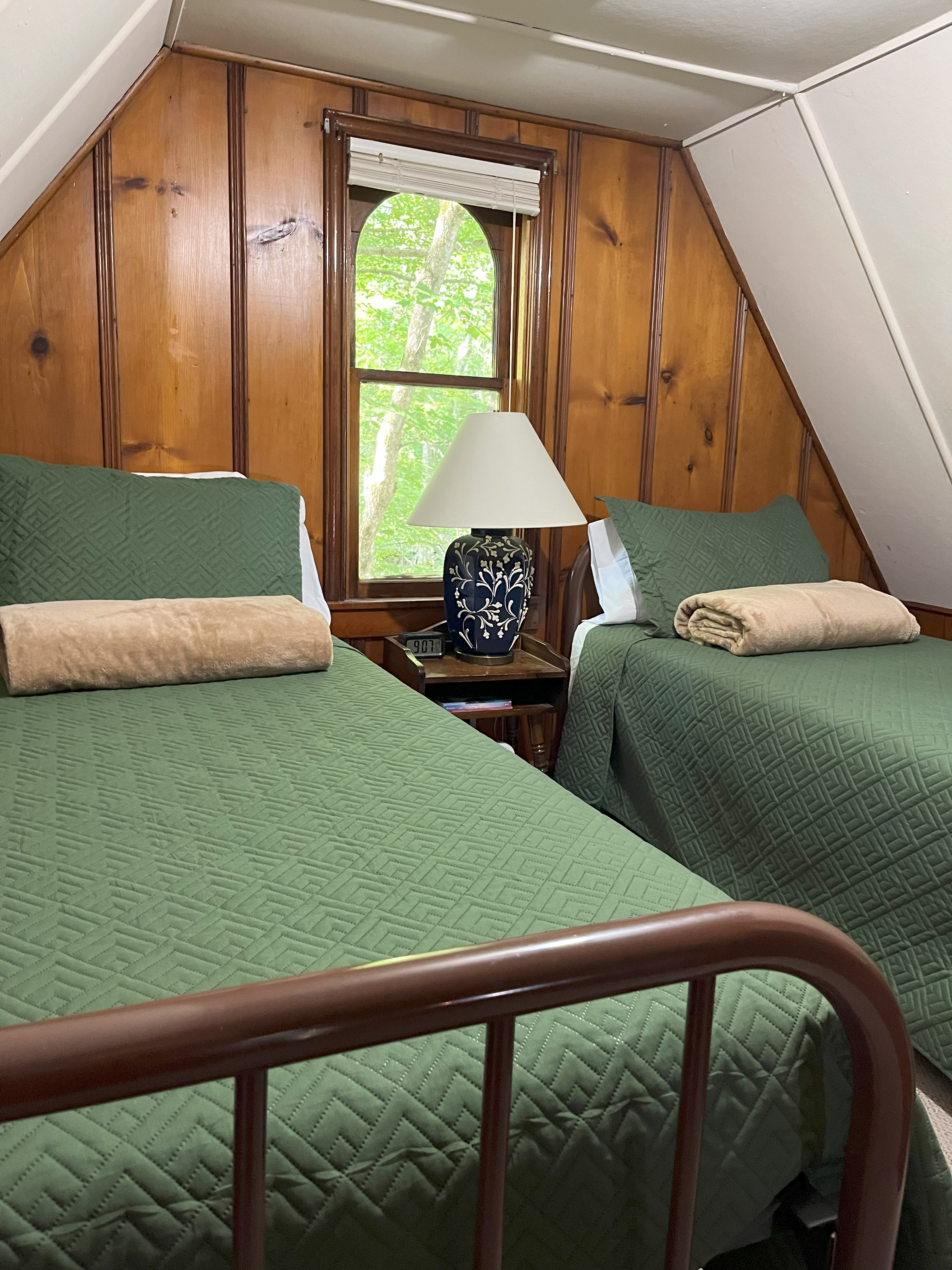 Artist's Cottage sleeping loft with twin beds and green quilts